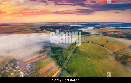 Landschaftsfotografie aus der Luft. Blick von der fliegenden Drohne auf neblige ukrainische Landschaft. Atemberaubender Sonnenaufgang im Sommer am Stadtrand von Ternopil, Ukrain Stockfoto