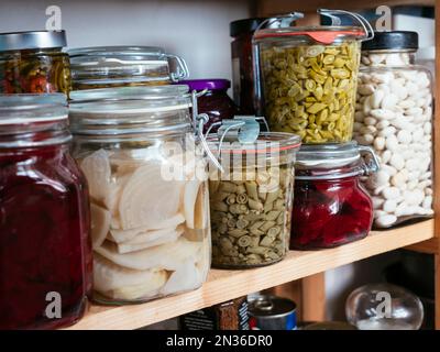 Gemüse aus Dosen (Bohnen, Rüben) in einer Speisekammer Stockfoto