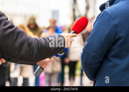 Reporter, der Medien macht, oder Vox-Populi-Interview mit nicht erkennbarem Mann Stockfoto