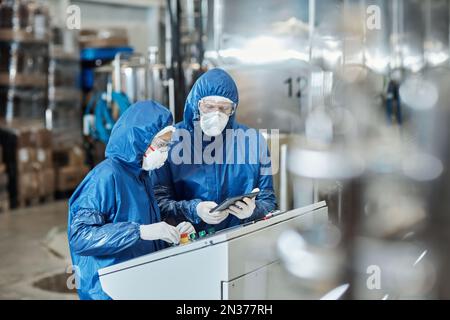 Porträt von zwei Arbeitern, die in einem Industriewerk Schutzausrüstung tragen Stockfoto