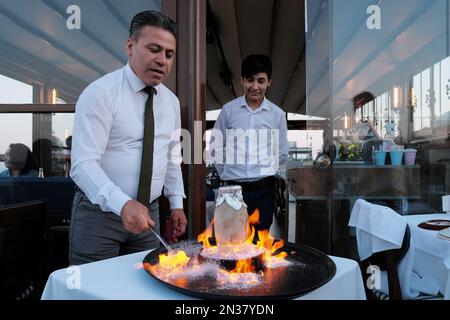 Koch bereitet das türkische Nationalgericht Testi Kebab in einem Topf zu, der vor der Verwendung platzt, in einem Dachrestaurant in Istanbul, Türkei. Stockfoto