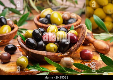 Kalamata, grüne und schwarze Oliven in der Holzschale. Hintergrund der Speisen. Stockfoto