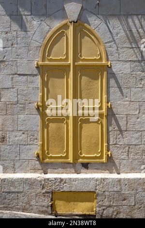 Bethlehem, Westjordanland, Palästina - 21. Juli 2022: Wunderschöne gelbe Fenster in einer alten weißen Steinmauer Stockfoto