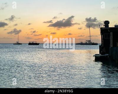 Segelboote am Horizont bei Sonnenuntergang, auf dem karibischen Meer, vor der Küste von Aruba Stockfoto