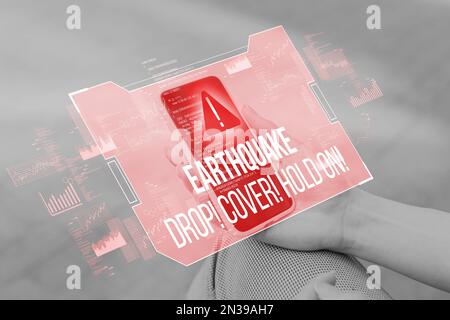 Eine Person hält ein Smartphone mit einer abstrakten Erdbebenmeldung und muss gerettet werden. Stockfoto