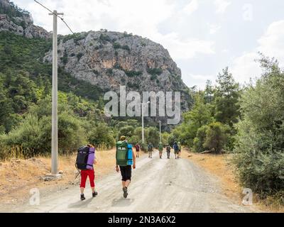 Touristen mit Rucksäcken laufen zum Goynuk Canyon. Wanderweg entlang der Berghänge im Beydaglari Coastal National Park. Truthahn. Stockfoto