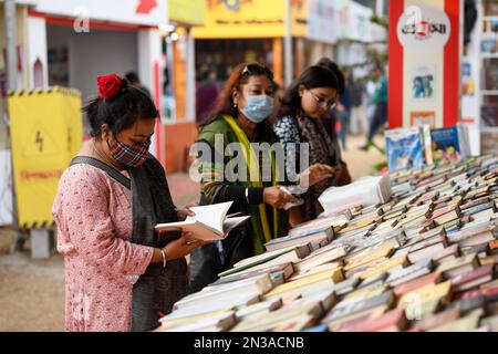 Dhaka, Bangladesch. 07. Februar 2023. Besucher lesen Bücher auf der nationalen Buchmesse Ekushey Boi Mela in Dhaka. Jedes Jahr organisiert die „Bangla Academy“ die nationale Buchmesse im Universitätsbereich von Dhaka. Diese Buchmesse ist die größte in Bangladesch und findet den ganzen Februar über statt. (Foto: Piyas Biswas/SOPA Images/Sipa USA) Guthaben: SIPA USA/Alamy Live News Stockfoto