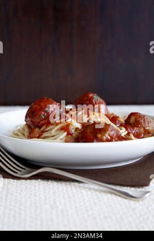 Schüssel Spaghetti mit Tomatensoße und Fleischbällchen mit Gabel Stockfoto