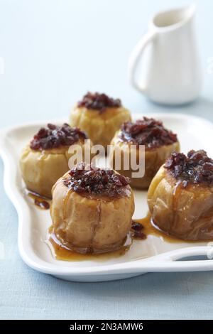 Gebackene Äpfel gefüllt mit Rosinen, Preiselbeeren und braunem Zucker Stockfoto