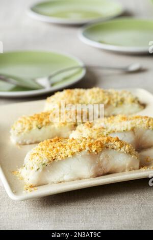 Weiße Fischstücke mit Panko-Kruste auf einer Servierplatte Stockfoto