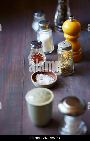 Stillleben von Salz- und Pfefferstreuern auf violettem Hintergrund Stockfoto