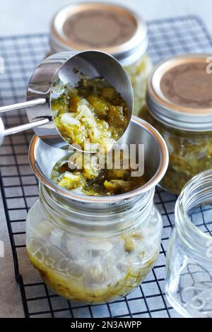 Tomatillo Salsa in Konservendosen schöpfen Stockfoto