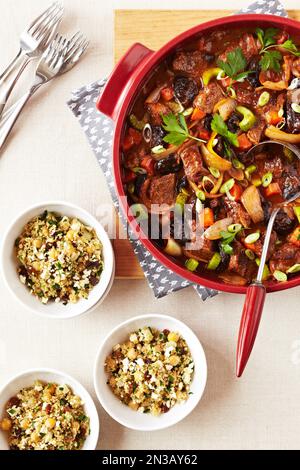 Rind-Tagine-Eintopf serviert mit Schüsseln Couscous Stockfoto