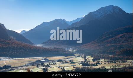 Straße im Engadin-Tal, die an einem sonnigen Herbstmorgen zum Bernina-Pass in der Schweiz führt Stockfoto