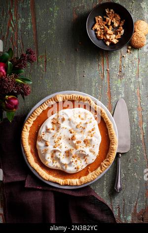 Kürbiskäsekuchen und Kuchenservice auf grauem Holzhintergrund Stockfoto