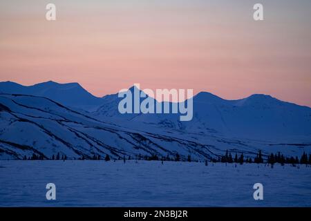 Die Sonne untergeht auf schneebedeckten Berggipfeln in der Alaska Range bei Paxson, Black Rapids und Glenallen; Alaska, Vereinigte Staaten von Amerika Stockfoto