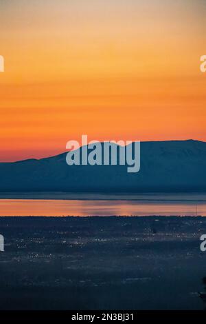 Die Sonne untergeht über dem Mt. Susitna oder Sleeping Lady, gegenüber Cook Inlet von Downtown Anchorage, Alaska auf Dena’ina Land, mit Blick auf Knik Arm Stockfoto