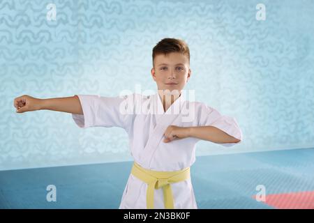 Ein Junge in Kimono, der Karate im Fitnessstudio übt Stockfoto