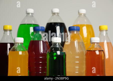 Flaschen mit alkoholfreien Getränken auf grauem Hintergrund, Nahaufnahme Stockfoto