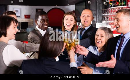 Internationale Gruppe von Geschäftsleuten, die mit Champagner toasten und sich auf der Büroparty im Nachtclub amüsieren Stockfoto