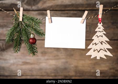 Leere Weihnachtskarte und festliche Einrichtung mit Seil vor Holzhintergrund. Platz für Text Stockfoto