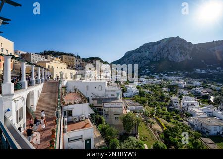 Die Leute gehen die Treppe hinauf zu einem Aussichtspunkt auf der Terrasse mit einem Überblick über die Stadt Capri, auf einem Plateau wie ein Sattel hoch über dem Meer mit der Insel... Stockfoto