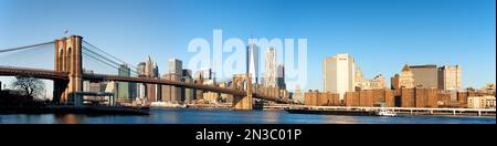 Eine breite Fotografie der Skyline von New York City und der Brooklyn Bridge, aufgenommen von Dumbo, Brooklyn. Stockfoto