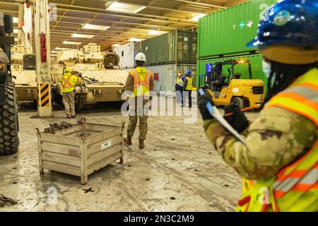 Charleston, South Carolina, USA. 25. Januar 2023. Soldaten mit dem 841. Transportschiff unterstützen die Stevedores beim Park von Bradley Kampffahrzeugen innerhalb der ARC Integrity am 25. Januar 2023 in North Charleston, South Carolina. Mehr als 60 Bradleys wurden von den USA ausgeliefert Transportation Command als Teil des US-Militärhilfepakets für die Ukraine. USTRANSCOM ist ein Kämpferkommando, das sich darauf konzentriert, militärische Macht zu einem Zeitpunkt und an einem Ort seiner Wahl zu projizieren und zu erhalten, um amerikanische Interessen auf der ganzen Welt voranzubringen. (Kreditbild: © Oz Suguitan/USA Transportation Command/ZUMA Press Wire S. Stockfoto