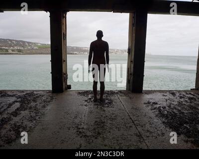 Blick von hinten auf Antony Gormleys Another Time 1999-2013, gusseiserne Figur, Folkestone Harbour Arm; Folkestone, Kent, England, Vereinigtes Königreich Stockfoto