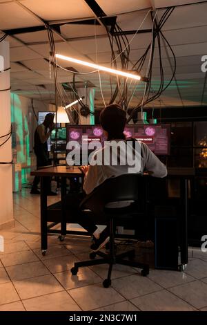 System hat Warnung auf mehreren Monitoren gehackt, Warnung wird gelesen, bevor auf den Datenbankserver zugegriffen wird. Hacker-Dieb, der spät in der Nacht einen Cyber-Angriff plant und persönliche Informationen für Ransomware stiehlt. Stockfoto