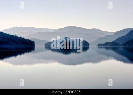 Der Nebel löst sich langsam über den Inseln und den reflektierenden, ruhigen Gewässern im Sitka Sound auf. Alexander Archipel hat etwa 1.100 Inseln, die... Stockfoto