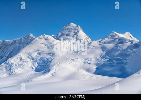 Blick aus der Vogelperspektive auf den blauen Himmel über die atemberaubende Landschaft des Kluane National Park mit den schneebedeckten Berggipfeln und Gletschern, die das Land ausmachen... Stockfoto