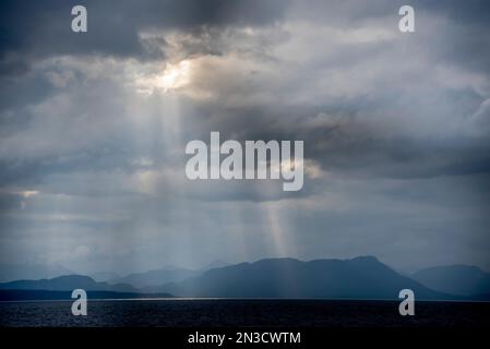 Sonnenlicht bricht durch Regenwolken in der Chatham Strait im Südosten Alaskas; Alaska, Vereinigte Staaten von Amerika Stockfoto