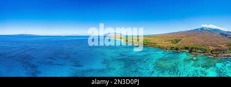 Aus der Vogelperspektive sehen Sie das türkisfarbene Wasser des Pazifiks, das die vulkanischen Inseln der hawaiianischen Inseln mit einem lebendigen blauen Himmel umgibt Stockfoto