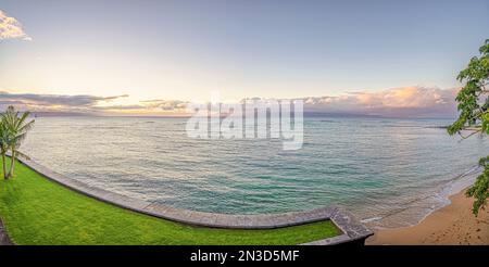 Blick auf den Ozean von der Küste eines Resorts in Lahaina mit Blick auf den Pazifik und einen blassblauen Himmel in der Dämmerung Stockfoto