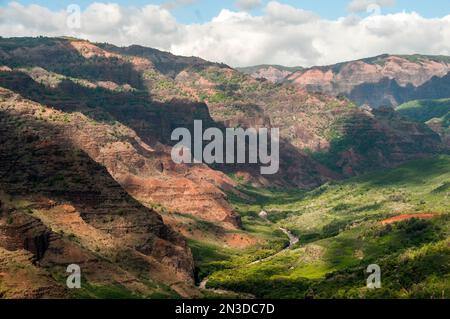 Sonne und Wolken prägen den Waimea Canyon auf der hawaiianischen Insel Kauai; Kauai, Hawaii, Vereinigte Staaten von Amerika Stockfoto