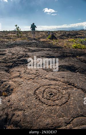 Touristen, die die PuIIuloa Petroglyphen erkunden, an der Südflanke des Vulkans Kīlauea auf der Big Island von Hawaii gelegen, ist PuIIuloa der Name... Stockfoto