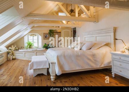 King Size antikes Holzbett im geräumigen Hauptschlafzimmer im Dachgeschoss in einem alten um 1840 Haus. Stockfoto