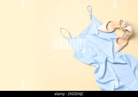 Stilvolles hellblaues Kleid und Schuhe auf beigefarbenem Hintergrund Stockfoto