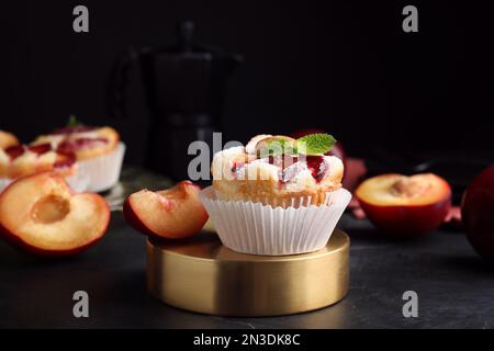 Leckere Cupcakes mit Pflaumen auf schwarzem Tisch, Nahaufnahme Stockfoto