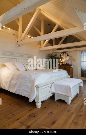 King Size antikes Holzbett im geräumigen Hauptschlafzimmer im Dachgeschoss in einem alten um 1840 Haus. Stockfoto