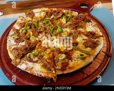 Rind, Käse, Pfeffer Pizza serviert auf einem Holzbrett Stockfoto