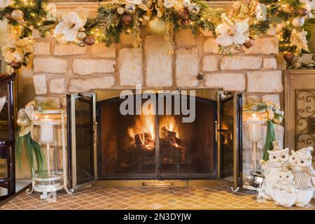 Holzkamin aus Naturstein mit Weihnachtsdekoration im Wohnzimmer im alten renovierten Haus im Canadiana-Cottage-Stil aus dem Jahr 1840. Stockfoto