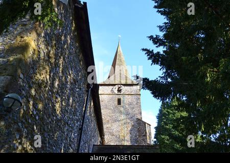 Cudham Church, Kent, Großbritannien. Eine normannisch-mittelalterliche Steinkirche mit alten Türen und Merkmalen aus dem 13. Jahrhundert. Umgeben von alten Eiben Stockfoto