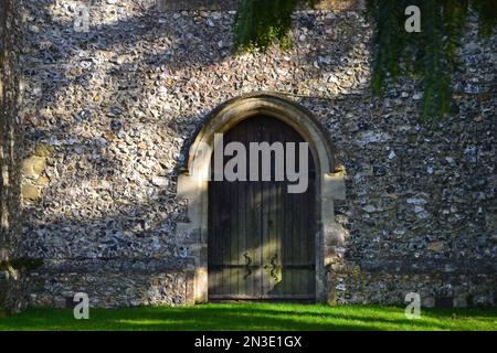 Cudham Church, Kent, Großbritannien. Eine normannisch-mittelalterliche Steinkirche mit alten Türen und Merkmalen aus dem 13. Jahrhundert. Umgeben von alten Eiben Stockfoto