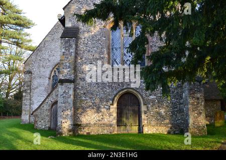 Cudham Church, Kent, Großbritannien. Eine normannisch-mittelalterliche Steinkirche mit alten Türen und Merkmalen aus dem 13. Jahrhundert. Umgeben von alten Eiben Stockfoto