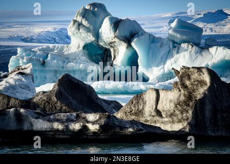 Schwarze und blaue Eisberge entlang der Küste der Gletscherlagune Jokulsarlon; Vatnajokull-Nationalpark, Island Stockfoto