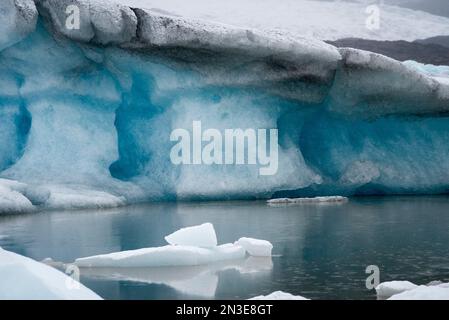 Aus nächster Nähe sehen Sie den Schneefall über Eisbergen entlang des Ufers der Gletscherlagune Jokulsarlon; Vatnajokull-Nationalpark, Island Stockfoto