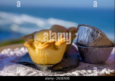 Portugiesische Gerichte, ofengebackene Hähnchenkuchen empada de Frango, serviert im Freien mit Blick auf den blauen, sonnigen Atlantik in der Nähe von Sintra im Raum Lissabon, Portugal Stockfoto