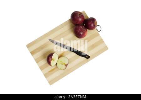 Geschnittener Apfel mit Messer auf Holzbrett isoliert auf weißem Hintergrund mit Schneideweg Stockfoto